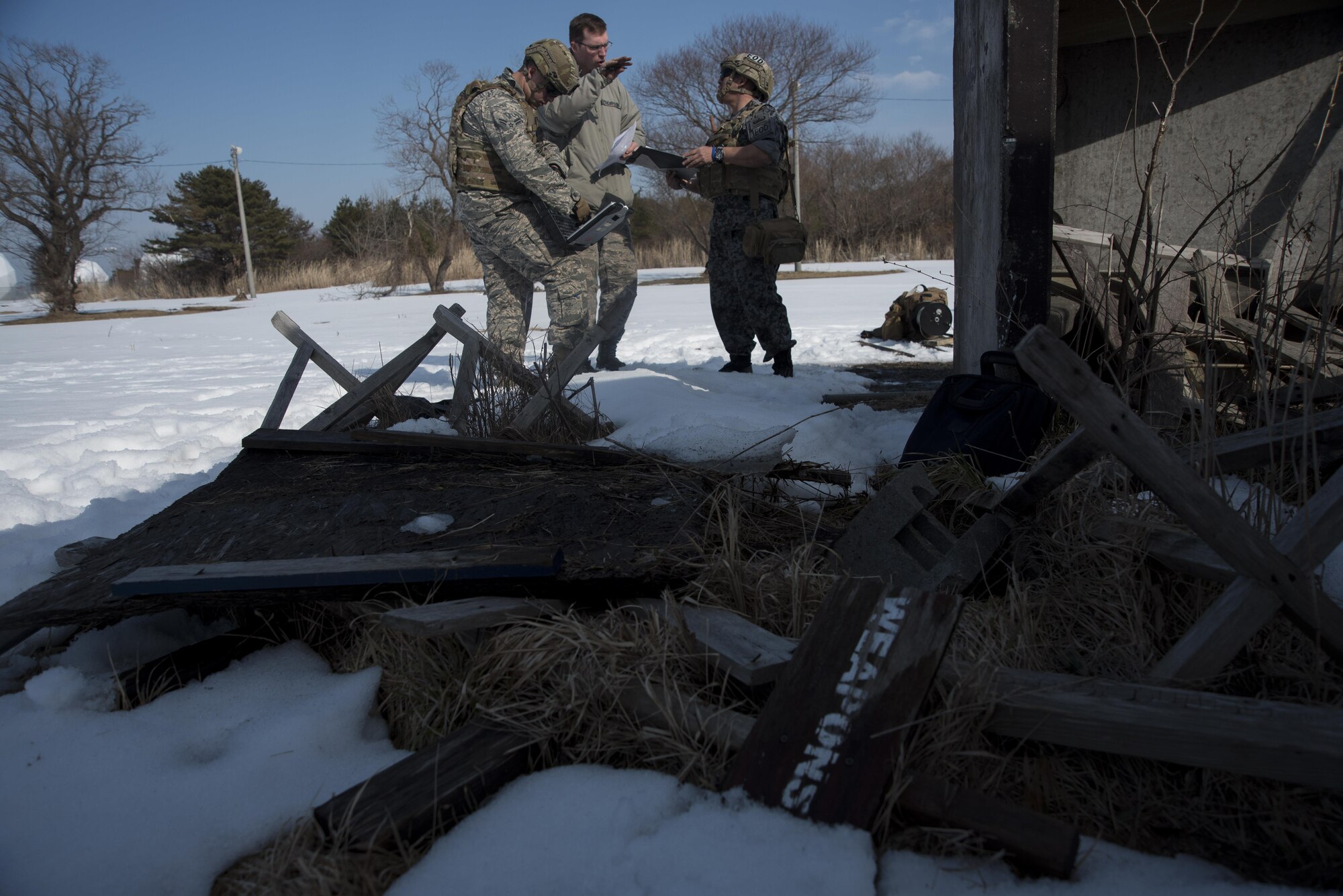 U.S. Air Force Airman 1st Class Matthew Melendez, left, Staff Sgt. Matthew Thompson, center, both 35th Civil Engineer Squadron explosive ordnance disposal technicians, and Japan Air Self-Defense Force Tech. Sgt. Shinji Okuzono, right, Tohoku EOD school instructor, discuss a plan of action for safe removal of an unexploded ordnance recovered during a training scenario at Misawa Air Base, Japan, March 2, 2017. The two day training was spent building a mutual understanding of foundational EOD skills, including classroom instruction and realistic hands-on practical exercises. (U.S. Air Force photo by Staff Sgt. Melanie A. Hutto)