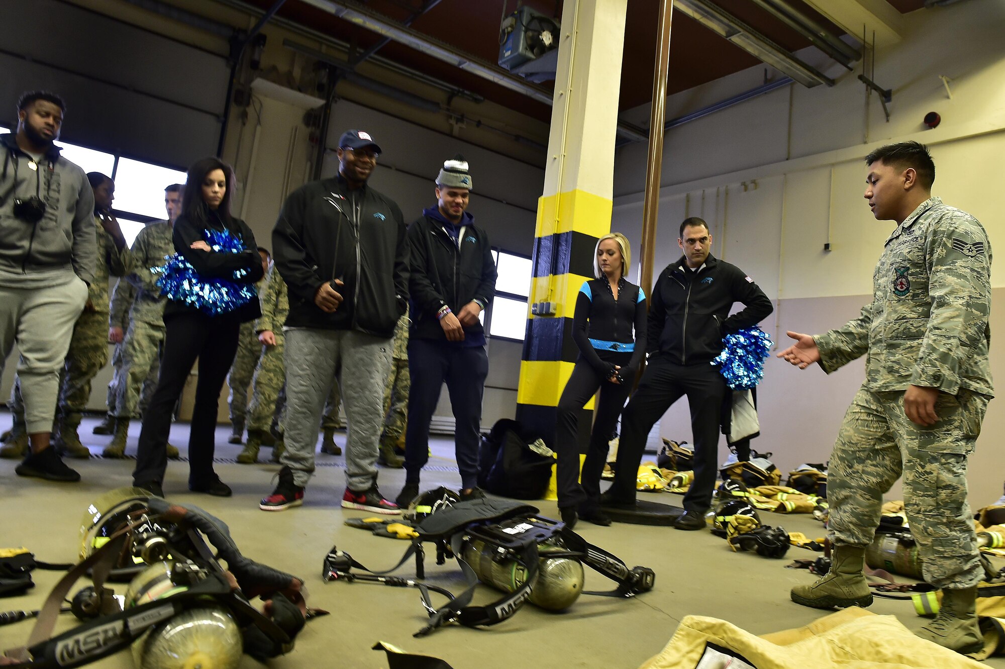 A 86th Civil Engineer Squadron fire and emergency services Airman briefs Carolina Panthers players and cheerleaders during a tour of fire station one on Ramstein Air Base, Germany, March 7, 2017. The Panthers spent two days with Airmen and their families in the Kaiserslautern Military Community. (U.S. Air Force photo by Senior Airman Jonathan Bass)