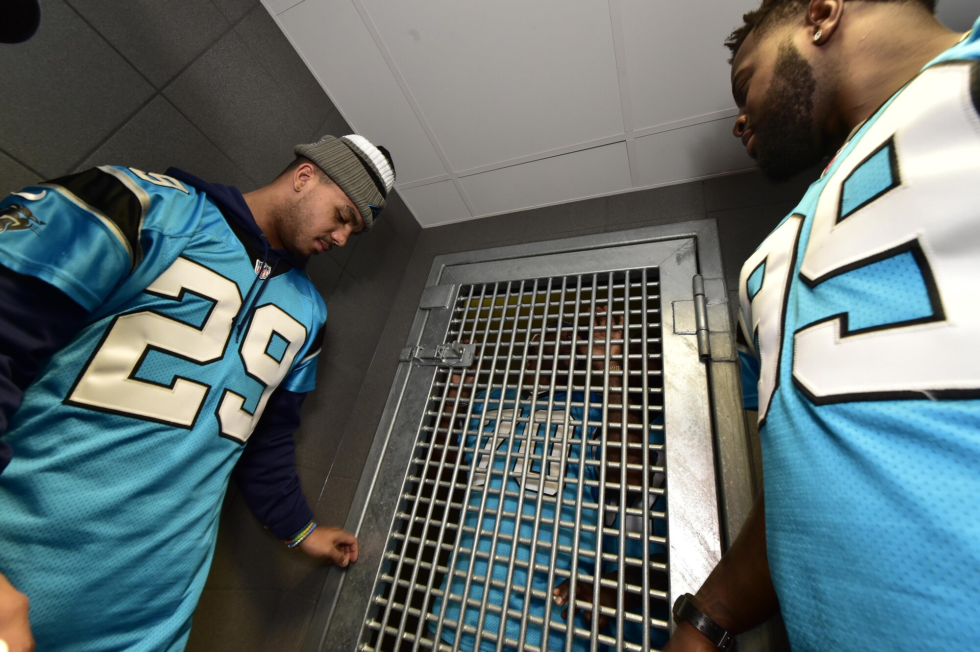 Dean Marlowe, Carolina Panthers safety, left, and Kawann Short, Carolina Panthers defensive tackle, right, lock Trai Turner, Carolina Panthers right guard, in a detention cell in the 569th U.S. Forces Police Squadron headquarters on Vogelweh Military Complex, Germany, March 7, 2017. The Panthers players received a tour of the 569th USFPS complex during their visit to the squadron. (U.S. Air Force photo by Senior Airman Jonathan Bass)