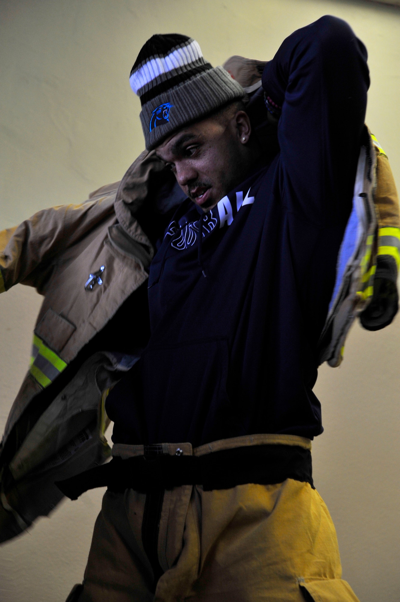 Dean Marlowe, Carolina Panthers safety, tries on fire protection gear during a visit to the 86th Civil Engineer Squadron Fire Station one on Ramstein Air Base, Germany, Mar. 7, 2017. During the visit by the Carolina Panthers, several players and cheerleaders toured units located in the local Kaiserslautern Military Community. (U.S. Air Force photo by Airman 1st Class D. Blake Browning)