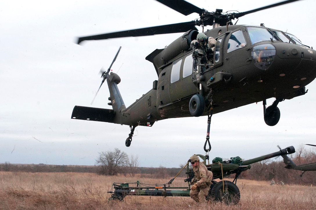 Oklahoma Army National Master Sgt. Richard Harp rushes away after hooking a towed howitzer to UH-60 Black Hawk helicopters during slingload and live-fire training at Fort Sill, Okla., March 4, 2017. Harp is assigned to Headquarters Battery, 1st Battalion, 160th Field Artillery Regiment. Oklahoma Army National Guard photo by Sgt. Bradley Cooney