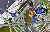 Tech. Sgt. Ryan Joslin, 1st Communications Maintenance Squadron NCO in charge of quality assurance assistance, hangs from an individual descender cable during tower rescue and climbing training on Ramstein Air Base, Germany, March 9, 2017. The 1 CMXS Airmen took turns as a rescuer and simulated victim during the training. (U.S Air Force photo by Senior Airman Tryphena Mayhugh)