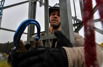Staff Sgt. Tyler Crawford, 1st Communications Maintenance Squadron cable and antenna maintenance technician, moves a simulated victim’s pelican hook from the tower to their harness before lowering them to the ground during tower rescue and climbing training on Ramstein Air Base, Germany, March 9, 2017. The training consisted of climbing approximately 50 feet up the tower, properly rigging a victim to an individual descender cable, and lowering them to the ground. (U.S Air Force photo by Senior Airman Tryphena Mayhugh)