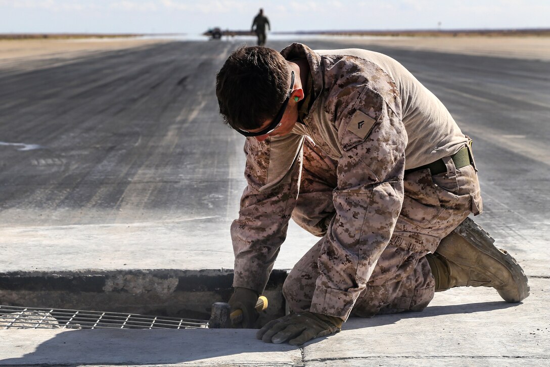 A Marine preps a pothole on a runway to be filled with concrete during maintenance at Al Asad Air Base, Iraq, March 4, 2017. Army photo by Sgt. Lisa Soy