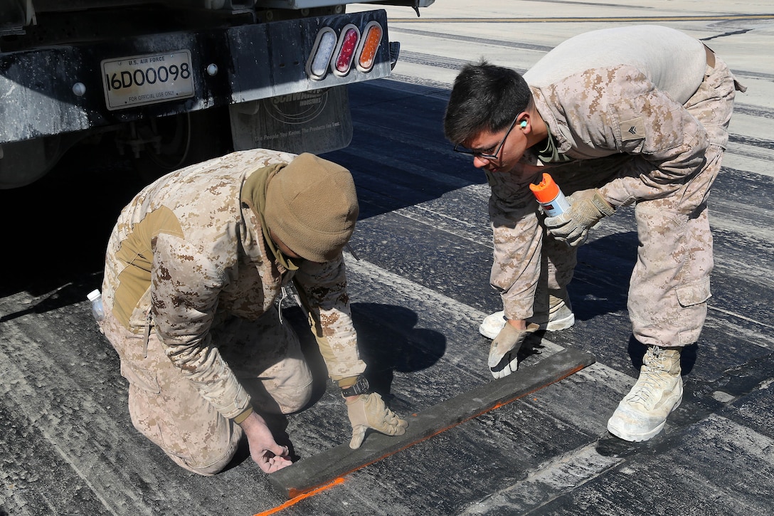 Marines use spray paint to mark a runaway during maintenance work at Al Asad Air Base, Iraq, March 4, 2017. Army photo by Sgt. Lisa Soy