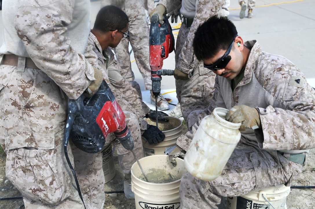 Marines mix cement to fill in potholes during maintenance on a runway at Al Asad Air Base, Iraq, March 4, 2017. Army photo by Sgt. Lisa Soy