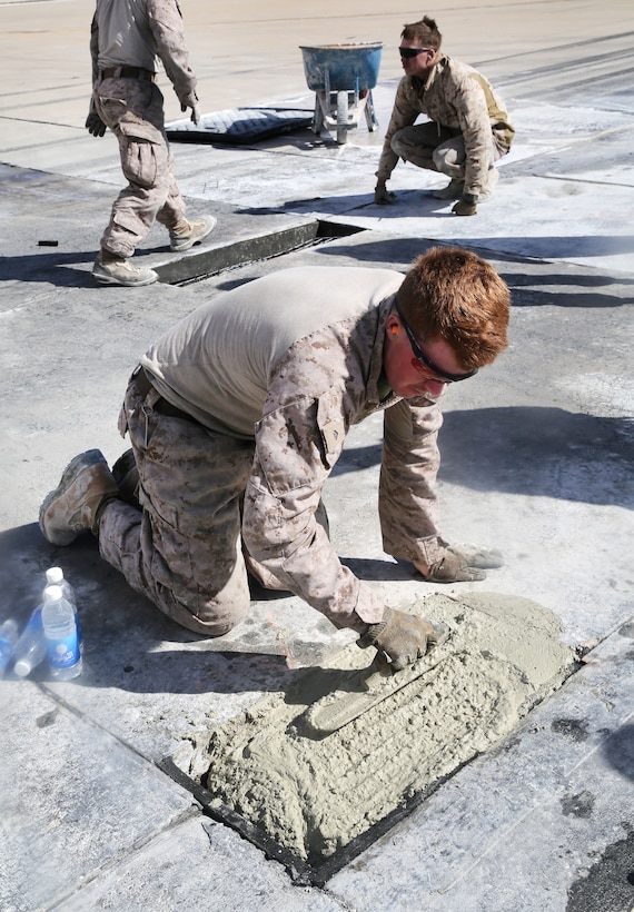 A Marine levels cement after filling a pothole during maintenance on a runway at Al Asad Air Base, Iraq, March 4, 2017. Army photo by Sgt. Lisa Soy