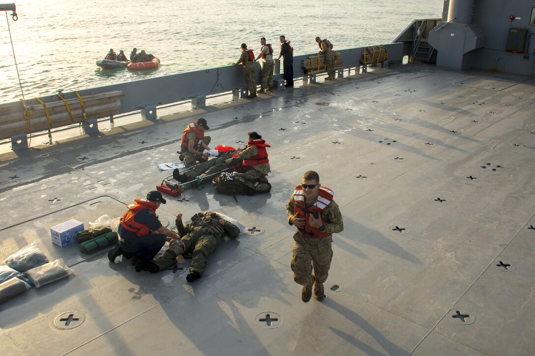 Kuwait-The Soldiers of the LCU2013 Churubusco- a Landing Craft Utility vessel from Detachment 1, 481st Transportation Company, California, render medical aid for their mock patients from 77th Combat Aviation Brigade, Arkansas, and Bravo company, 1-111th Aviation Regiment, Florida, during a personnel recovery mission replicating a downed aircraft scenario, Feb. 13. 
(Photo by Army Sgt. 1st Class Suzanne Ringle/Released)