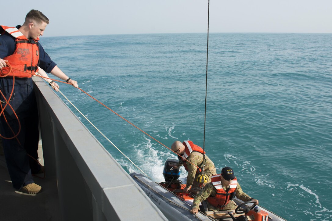 Kuwait-The Soldiers from the LCU2013 Churubusco- a Landing Craft Utility vessel from Detachment 1, 481st Transportation Company, California, hoist a small watercraft to the seas’ surface before speeding to the personnel acting lost at sea during a personnel recovery training mission replicating a downed aircraft scenario, Feb. 13. 
(Photo by Army Sgt. 1st Class Suzanne Ringle/Released)