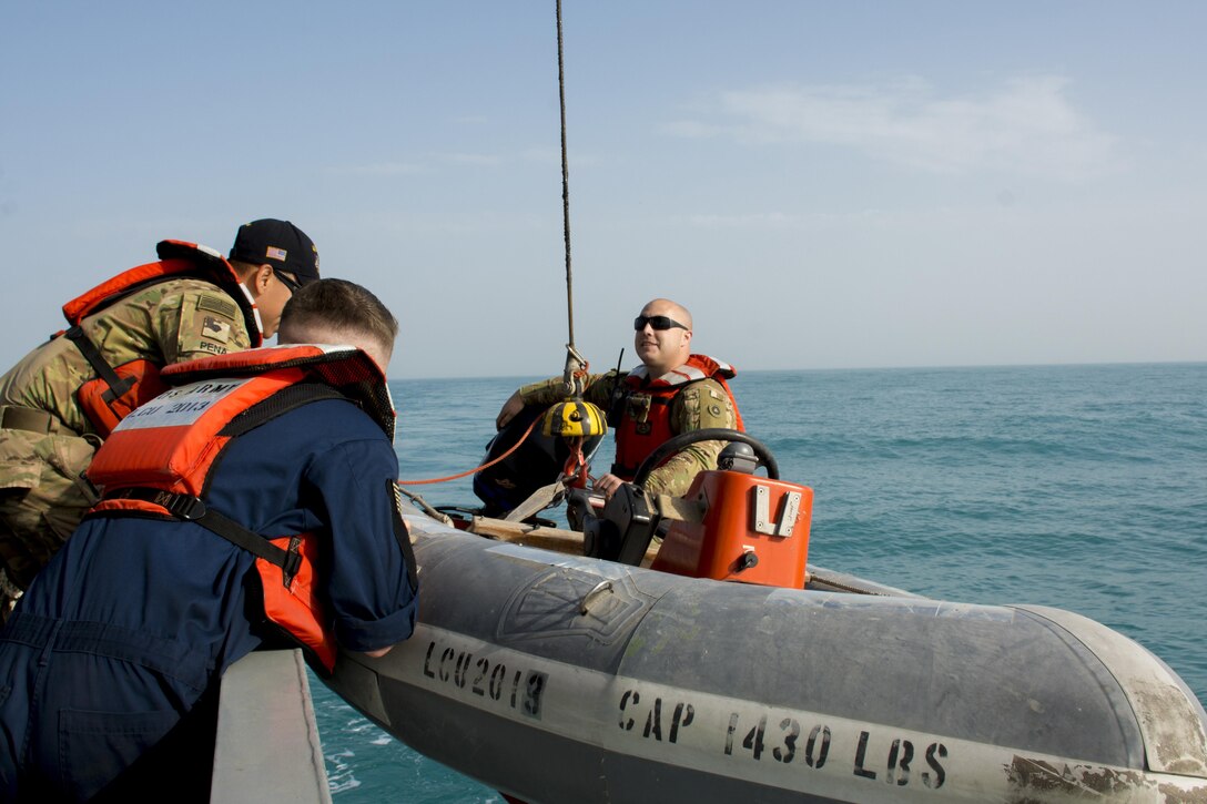 Kuwait-The Soldiers from the LCU2013 Churubusco- a Landing Craft Utility vessel from Detachment 1, 481st Transportation Company, California, hoist a small watercraft to the seas’ surface before speeding to the personnel acting lost at sea during a personnel recovery training mission replicating a downed aircraft scenario, Feb. 13. 
(Photo by Army Sgt. 1st Class Suzanne Ringle/Released)