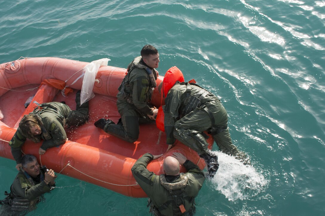 Kuwait- Soldiers climb aboard a survival raft to await rescue from the USAV Churubusco- a Landing Craft Utility vessel-  the crew, 481 det. 1, transportation company, California, during a personnel recovery training mission using  Bravo Company, 1-111th, Florida, Soldiers for the personnel lost at sea; the crew perform a grid pattern and use lookouts once located there is mock medical aid, Feb. 13. 
(Photo by Army Sgt. 1st Class Suzanne Ringle/Released)