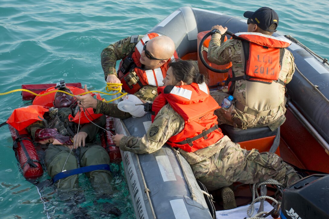 Kuwait-The Soldiers, Watercraft Operators and vessel medic, for the LCU2013 Churubusco- a Landing Craft Utility vessel from Detachment 1, 481st Transportation Company, California, grab a line thrown from the deck to hoist their mock patient from 77th Combat Aviation Brigade, Arkansas, while participating in a personnel recovery mission replicating a downed aircraft scenario, Feb. 13. 
(Photo by Army Sgt. 1st Class Suzanne Ringle/Released)