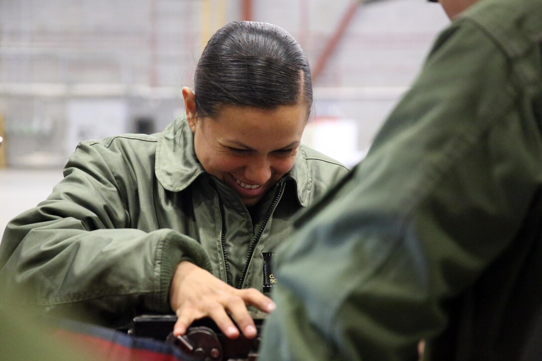 Sgt. Cristina Fuentes laughs with her fellow Marines as she conducts maintenance on a piece of flight equipment from a UH-1Y Venom aboard Ft. Drum, N.Y., Mar. 9, 2017. Marines assigned to Marine Light Attack Helicopter Squadron 269, Marine Aircraft Group 29, 2nd Marine Aircraft Wing arrived at Ft. Drum Mar. 8, and will spend more than a week conducting aerial operations in the cold environment. The training will also offer the Marines a unique opportunity to build unit comradery and cohesion through the challenges of the cold weather training. Fuentes is a crew chief assigned to HMLA-269. (U.S. Marine Corps photo by Cpl. Mackenzie Gibson/Released)