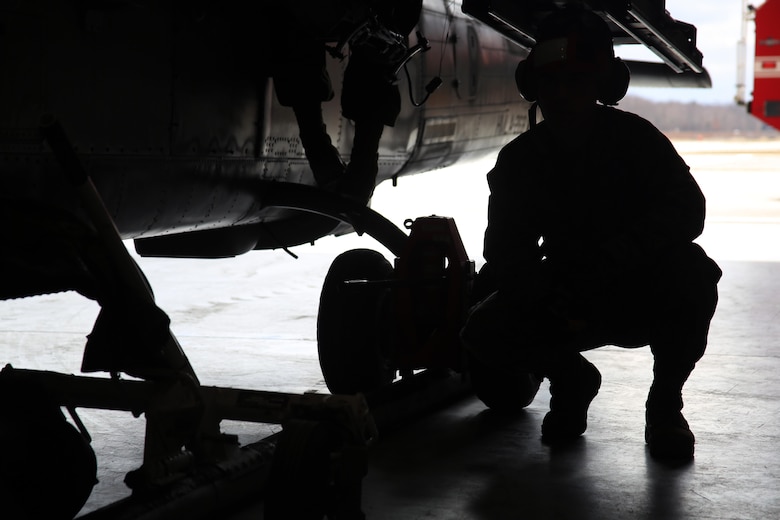 Pfc. Stetson Kirkpatrick crouches next to a UH-1Y Venom aboard Ft. Drum, N.Y., Mar. 9, 2017. Marines assigned to Marine Light Attack Helicopter Squadron 269, Marine Aircraft Group 29, 2nd Marine Aircraft Wing arrived at Ft. Drum Mar. 8, and will spend more than a week conducting aerial operations in the cold environment. The training will further hone the unit’s ability to operate anywhere around the world. Kirkpatrick is an aviation ordnance technician with HMLA-269. (U.S. Marine Corps photo by Cpl. Mackenzie Gibson/Released)