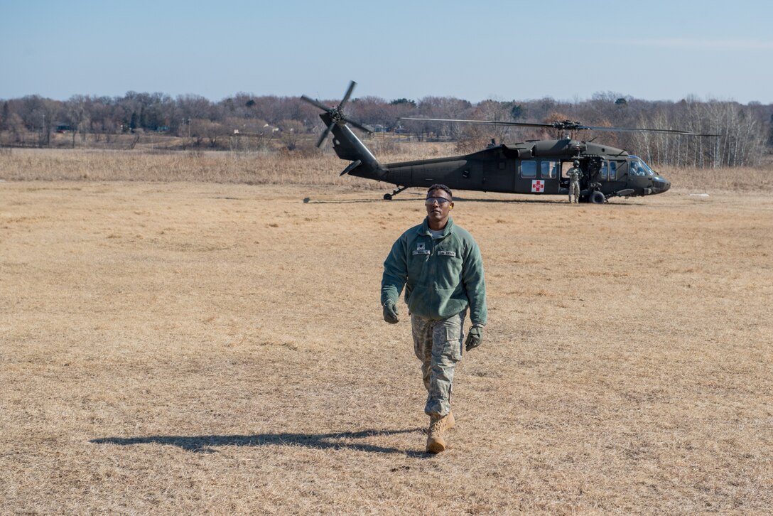 Army Specialist Mohamedkadar Idle of the 7212th Medical Support Unit walks away from a UH-60 Blackhawk helicopter during a joint service medical evacuation training on March 4th, 2017 at Arden Hills Army Training Site. (U.S. Air Force photo by Senior Airman Samuel Wacha)