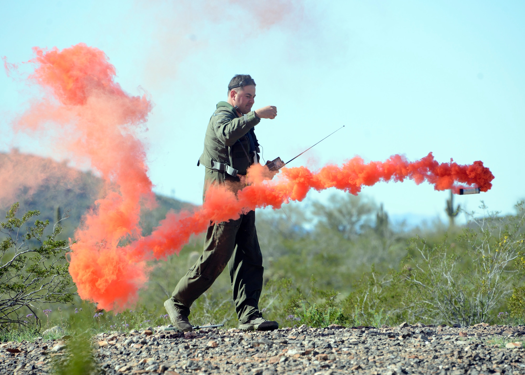 Maj. Nicholas Suppa, 56th Operations Support Squadron assistant director of operations, throws a smoke screen to alert rescue personnel during a Major Accident Response Exercise at a remote area in Arizona, March 1, 2017. The exercise highlighted the way Air Force and civilian assets can be used together to more effectively respond to crises, and potentially save lives.  (U.S. Air Force photo by Senior Airman Devante Williams)