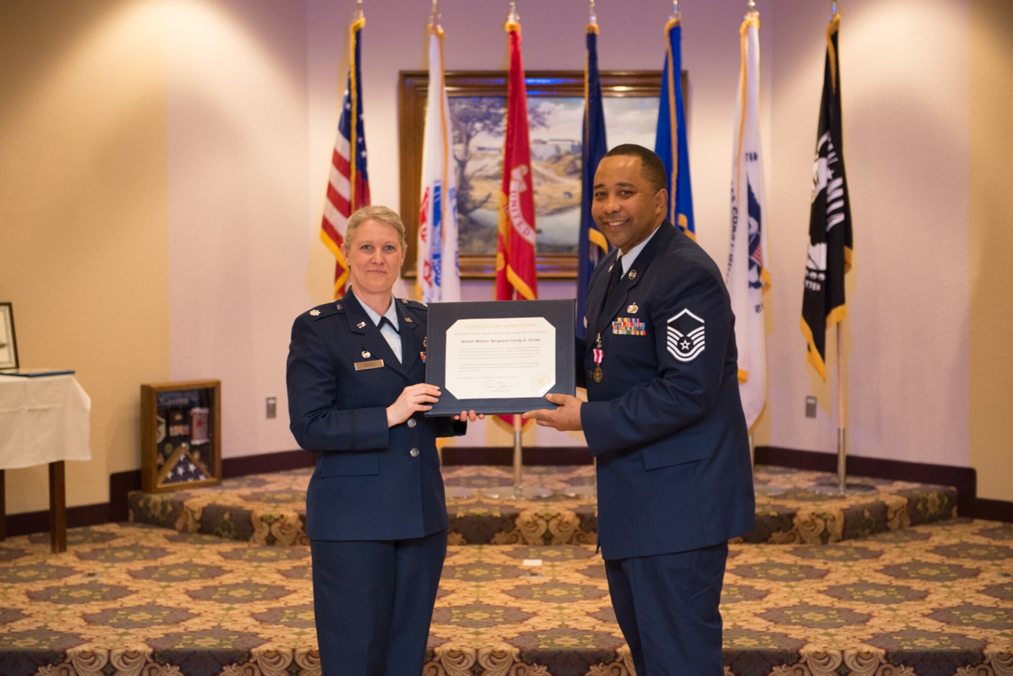 Master Sgt. Marlon B. Crawford receives his retirement certificate from the FSS Commander, Lt. Col. Kristiana Gerdes on 5 March. (U.S. Air Force Photo by Tech. Sgt. Trevor Saylor)