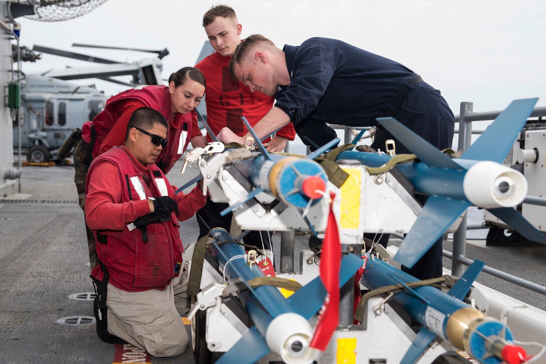From left, Navy Chief Oliver Christofferson, shows Petty Officer 3rd Class Ciara Poder, Petty Officer 3rd Class Austin Hoffman, and Petty Officer 3rd Class Ian Callahan how to prepare laser guided training bombs on the flight deck of amphibious assault ship USS Bonhomme Richard in the Philippine Sea, March 10, 2017. The training bombs permit aircrews to practice delivery tactics and experience actual weapon characteristics. Navy photo by Seaman Jesse Marquez Magallanes