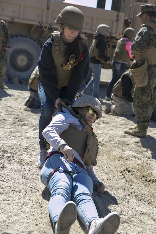 Jelanie Cisneros, wife of Sgt. Oscar Cisneros, tank commander, 1st Tank Battalion, drags Kimberle Aponte, wife of Lance Cpl. Andrew Aponte, tank gunner, 1st Tanks, during the battalion’s Jane Wayne Day at Range 500 aboard Marine Corps Air Ground Combat Center, Twentynine Palms, Calif., March 2, 2017. The event is held to bolster unit cohesion while allowing the spouses to see what their Marines and sailors do on a daily basis. (U.S. Marine Corps photo by Cpl. Julio McGraw)
