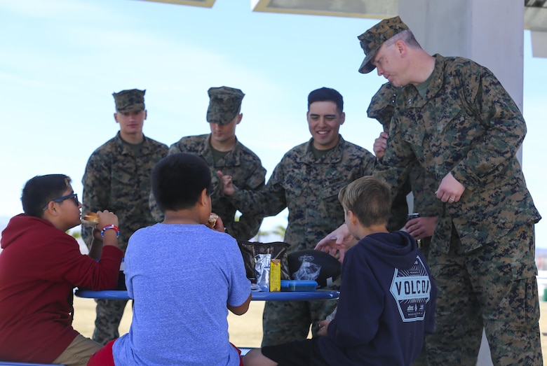 Fourth and fifth-grade students from Palm Vista Elementary school eat lunch with Marines from 3rd Battalion, 4th Marines, 7th Marine Regiment at Victory Park following the annual Battle Color Ceremony at Lance Cpl. Torrey L. Gray Field aboard Marine Corps Air Ground Combat Center, Twentynine Palms, Calif., March 8, 2017. 3/4 adopted the elementary school in order to mentor the children and remain involved in the community.  (U.S. Marine Corps photo by Lance Cpl. Natalia Cuevas)