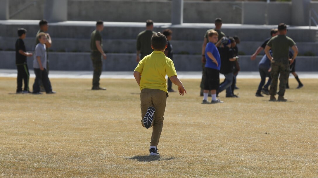 Fourth and fifth-grade students from Palm Vista Elementary school play kickball with Marines from 3rd Battalion, 4th Marines, 7th Marine Regiment at Victory Park following the annual Battle Color Ceremony at Lance Cpl. Torrey L. Gray Field aboard Marine Corps Air Ground Combat Center, Twentynine Palms, Calif., March 8, 2017. 3/4 adopted the elementary school in order to mentor the children.  (U.S. Marine Corps photo by Lance Cpl. Natalia Cuevas)