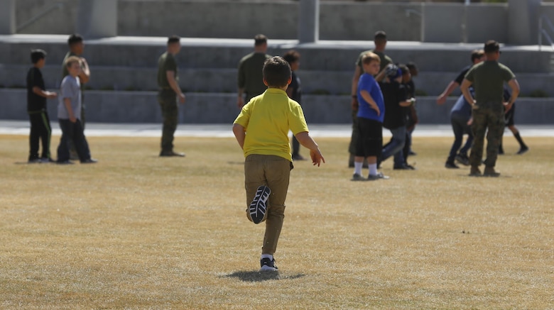 Fourth and fifth-grade students from Palm Vista Elementary school play kickball with Marines from 3rd Battalion, 4th Marines, 7th Marine Regiment at Victory Park following the annual Battle Color Ceremony at Lance Cpl. Torrey L. Gray Field aboard Marine Corps Air Ground Combat Center, Twentynine Palms, Calif., March 8, 2017. 3/4 adopted the elementary school in order to mentor the children.  (U.S. Marine Corps photo by Lance Cpl. Natalia Cuevas)