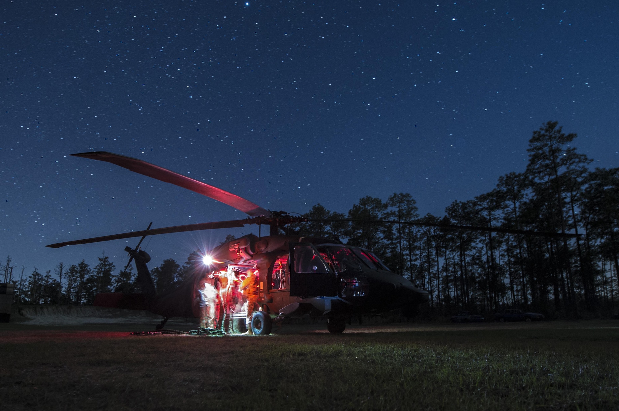 Members of the 7th Special Forces Group attatch a hoist to U.S. Army UH-60L Black Hawk at Eglin Air Force Base, Fla., March 3, 2017 during Emerald Warrior 17. Emerald Warrior is a U.S. Special Operations Command exercise during which joint special operations forces train to respond to various threats across the spectrum of conflict. (U.S. Air Force photo/Airman 1st Class Keifer Bowes)