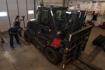 (From left) Senior Airman Nicholas Oukrop, 5th Logistics Readiness Squadron vehicle maintenance technician, and Airman Steven Velasquez, 5th LRS vehicle maintenance technician, mount a tire onto a forklift at Minot Air Force Base, N.D., Feb. 28, 2017. Tire shop maintainers are responsible for ensuring base government vehicle tires remain in serviceable condition. (U.S. Air Force photo/Airman 1st Class Jonathan McElderry)