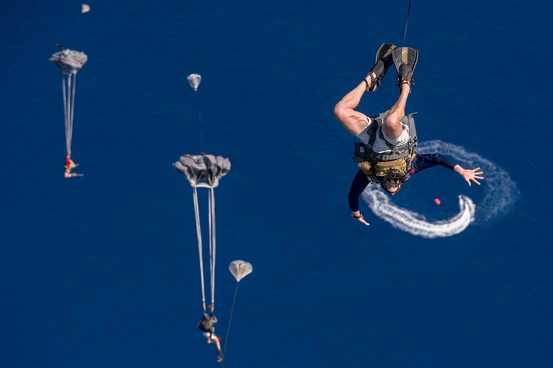 New York Air National Guard pararescuemen and combat rescue officers jump from a Hawaii Air National Guard C-17 Globemaster III into the ocean near Joint Base Pearl Harbor-Hickam, Hawaii, March 7, 2017, as they train to test new techniques and equipment that will be used to recover the crew module of NASA's Orion spacecraft. The airmen are assigned to the 103rd Rescue Squadron. Air National Guard photo by Staff Sgt. Christopher Muncy