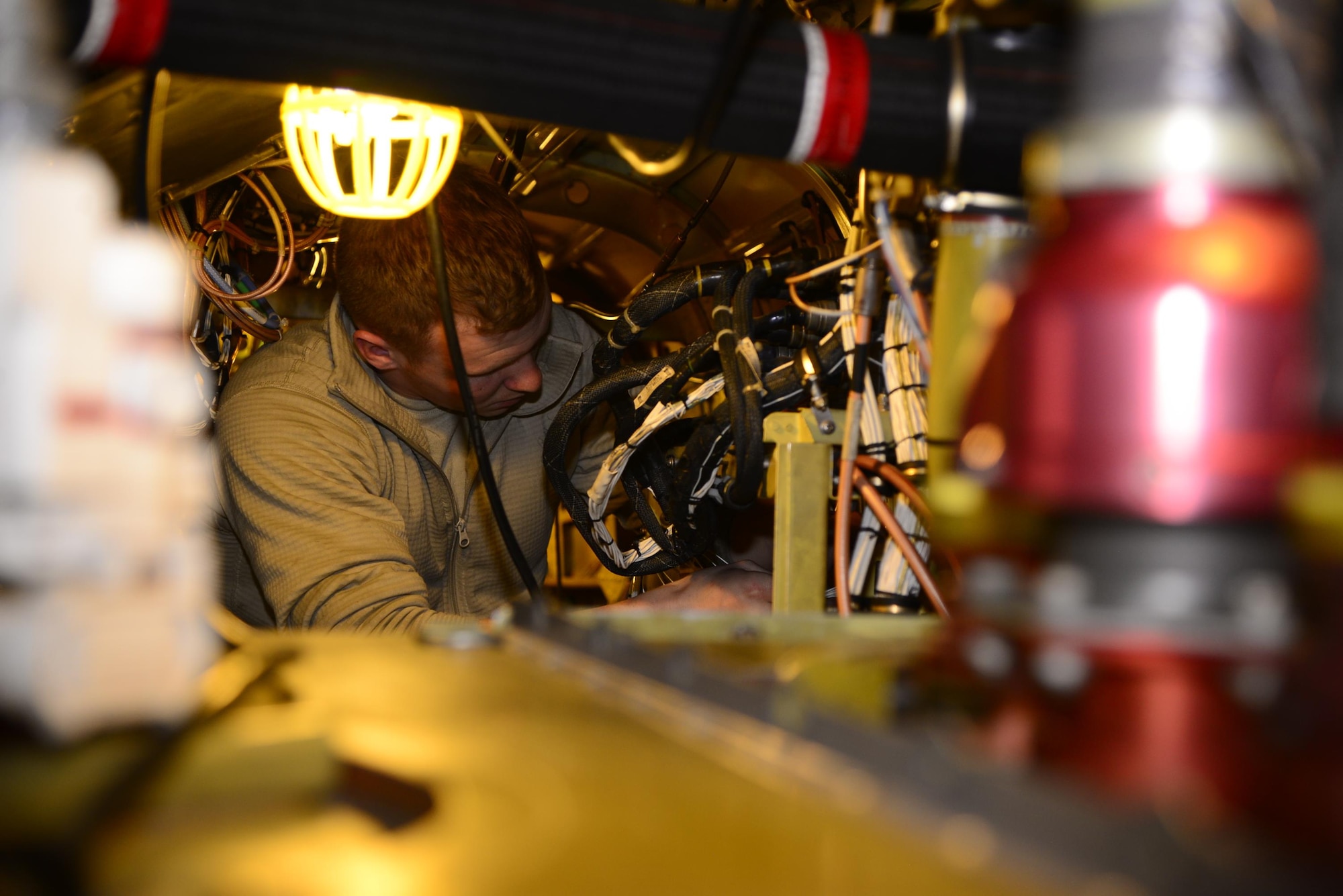 U.S. Air Force Staff Sgt. Joseph Drees, 55th Helicopter Maintenance Unit communication, navigation and mission systems journeyman, connects a grounding wire in an HH-60G Pave Hawk during a phase inspection at Davis-Monthan Air Force Base, Ariz., March 8, 2017. A phase inspection is a complete teardown of the aircraft parts to check for any cracks or discrepancies. (U.S. Air Force photo by Senior Airman Betty R. Chevalier)