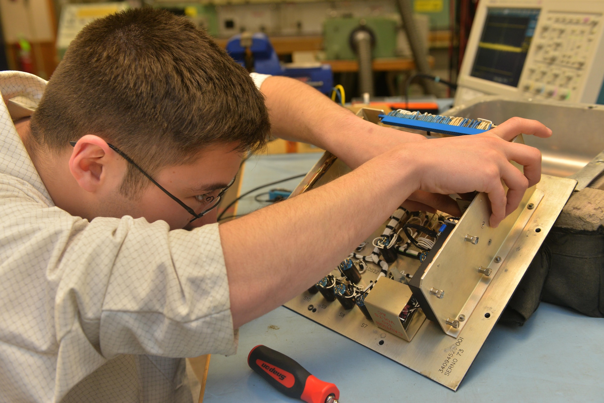 Senior Airman Maxwell Clement, 791st Maintenance Squadron electronic laboratory technician, removes a controller monitor filter at Minot Air Force Base, N.D., March 2, 2017. Electronic laboratory technicians inspect, troubleshoot, and repair electronic components and test equipment for launch facilities and launch control centers. (U.S. Air Force photo/Airman 1st Class Jessica Weissman)