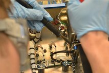 A technician from the 791st Maintenance Squadron electronics laboratory de-solders a wire on a controller monitor at Minot Air Force Base, N.D., March 2, 2017. The ELAB technicians work with different agencies, such as the electro-mechanical team, vehicles and equipment, and facilities maintenance sections. (U.S. Air Force photo/Airman 1st Class Jessica Weissman)