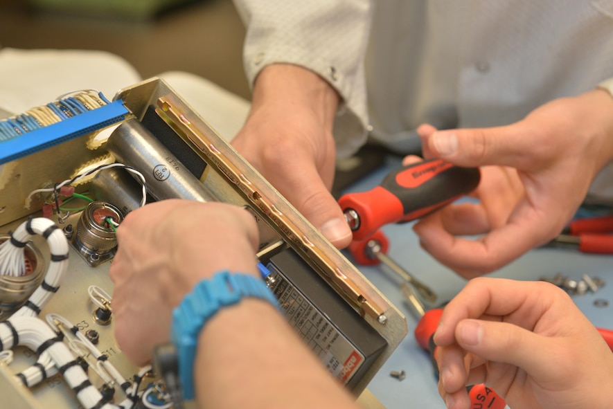 Technicians from the 791st Maintenance Squadron electronics laboratory remove screws from a controller monitor at Minot Air Force Base, N.D., March 2, 2017. Electronic laboratory technicians inspect, troubleshoot, and repair electronic components and test equipment for launch facilities, and launch control centers. (U.S. Air Force photo/Airman 1st Class Jessica Weissman)