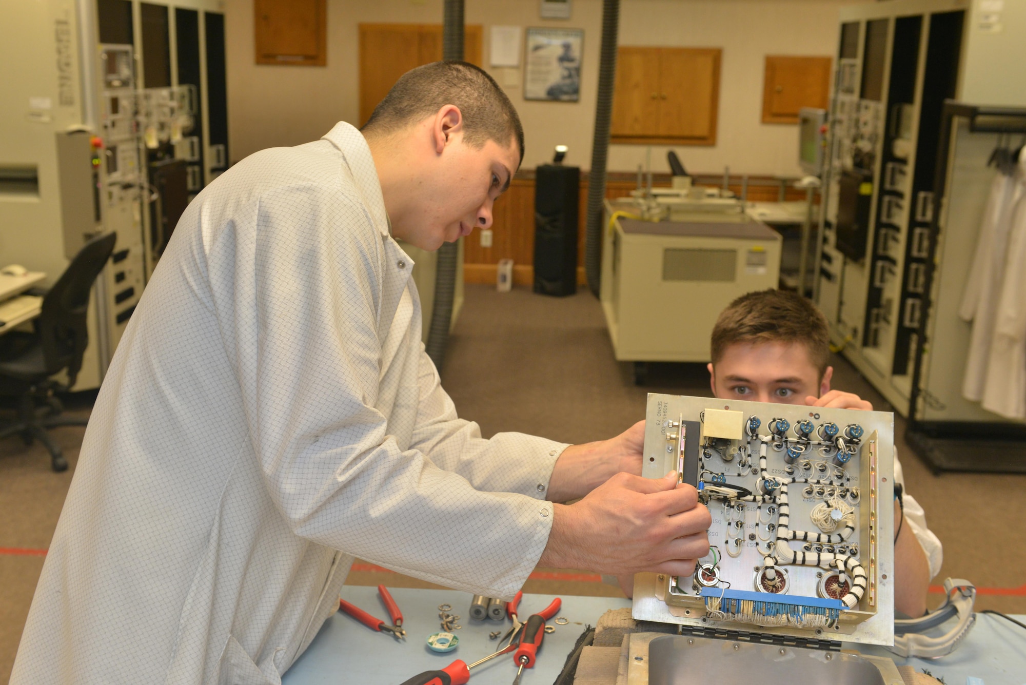 (From left) Staff Sgt. Dylan Wood, 791st Maintenance Squadron electronics laboratory trainer, and Senior Airman Maxwell Clement, 791st MXS ELAB technician, remove faulty components from a controller monitor at Minot Air Force Base, N.D., March 2, 2017. Electronic laboratory technicians are responsible for maintenance and quality assurance of the Minuteman III Intercontinental Ballistic Missile support equipment. (U.S. Air Force photo/Airman 1st Class Jessica Weissman)