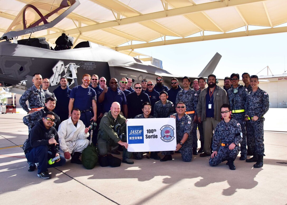 Members from the Japan Air Self-Defense Force, Lockheed Martin, and 944th Operations Group Detachment 2, pose for a photo Mar. 7 after the 100th sortie milestone at Luke Air Force Base, Ariz. (U.S. Air Force photo by Tech. Sgt. Louis Vega Jr.)