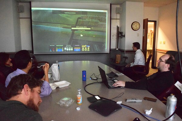 Mike Nielson, a Corps Hydrologic Technician, right, plays the newly-created educational game, “Flood Fighter: Nevada,” during a recent brown bag lunch at U.S. Army Corps of Engineers Sacramento District offices in order to gain feedback from the audience. Water resources planner Hunter Merritt, left rear, takes notes while listening to ideas and suggestions.(U.S. Army Photo by J. Paul Bruton/Released)