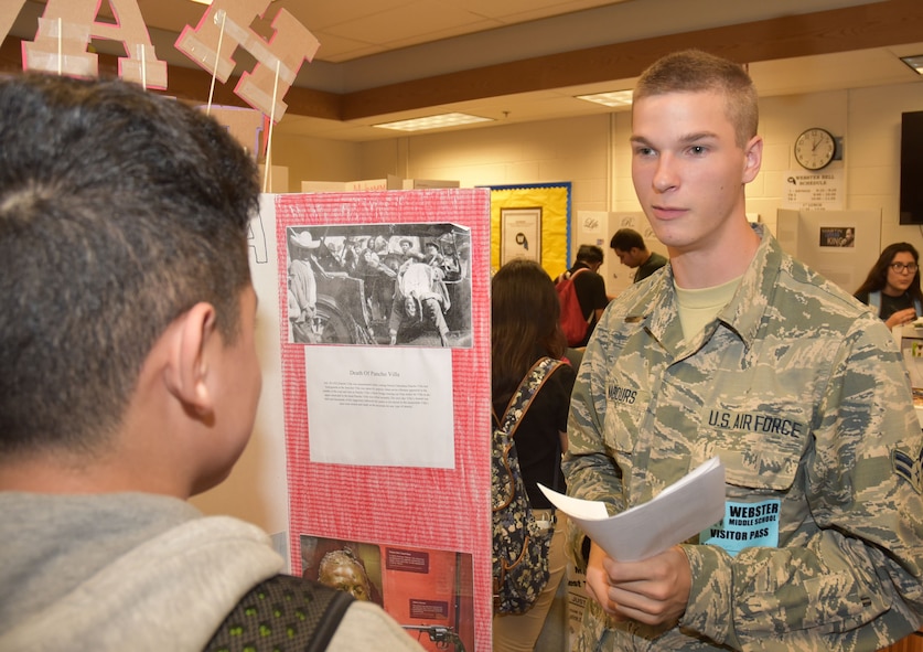 Airman First Class Daniel, 552nd Air Control Networking Squadron, listens as a student explains his historical project during the National History Day competition at Webster Middle School, Oklahoma City. Members of the 552nd Air Control Wing served as judges. (Air Force photo by Ron Mullan)