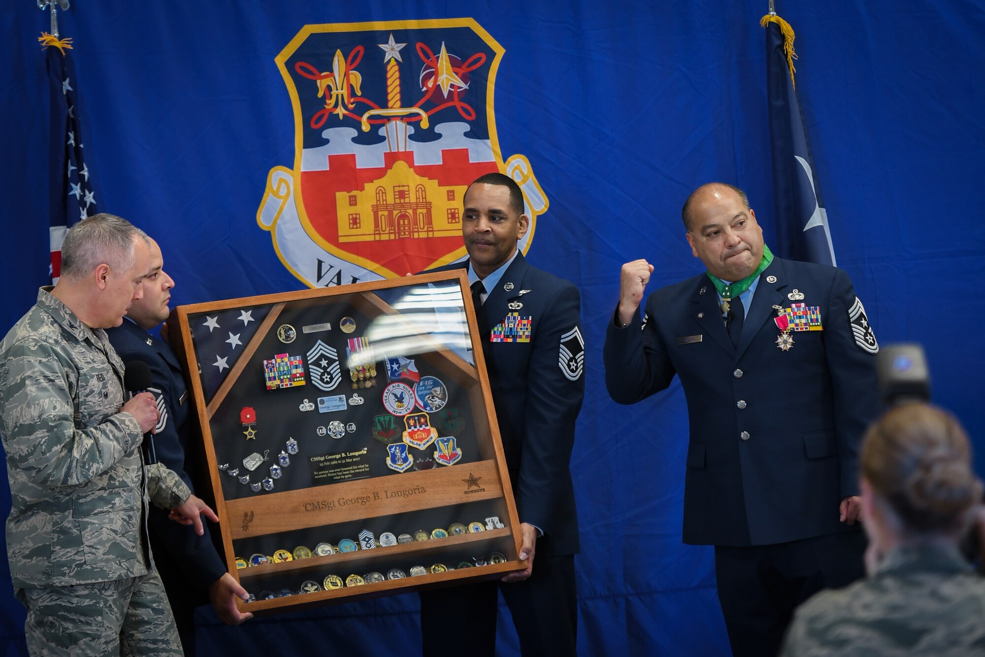 Command Chief Master Sgt. George Longoria (right) is presented a shadow box honoring his 35 years of military service by Col. Michael Reid (left), vice wing commander, Master Sgt. Albert Cardenas (second from left) and Senior Master Sgt. Marvin Williams (second from right), during his retirement ceremony at Joint Base San Antonio-Lackland, Texas, Feb. 25, 2017. Longoria retires after 35 years of service with the 149th Fighter Wing, Texas Air National Guard. (U.S. Air National Guard photo by Tech. Sgt. Eric L. Wilson)