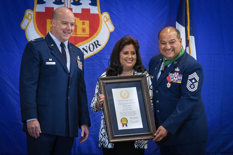 Command Chief Master Sgt. George B. Longoria (right) and his wife, Patty, hold a certificate signed by Texas Gov. Greg Abbott honoring Patty as a “Yellow Rose of Texas” for her support of Longoria during his military career at Joint Base San Antonio-Lackland, Texas, Feb. 25, 2017. The Longorias are joined by Col. Timothy Madden, commander of the 149th Fighter Wing, Texas Air National Guard. Longoria retires after 35 years of military service. (U.S. Air National Guard photo by Tech. Sgt. Eric L. Wilson)