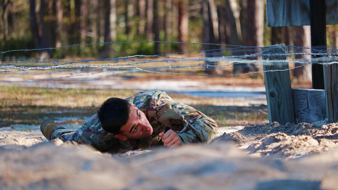 Army Spc. Mason Mackrell low-crawls under barbed wire during the Georgia National Guard Best Warrior Competition at Fort Stewart, Ga., March 9, 2017. Army photo by Sgt. James Braswell