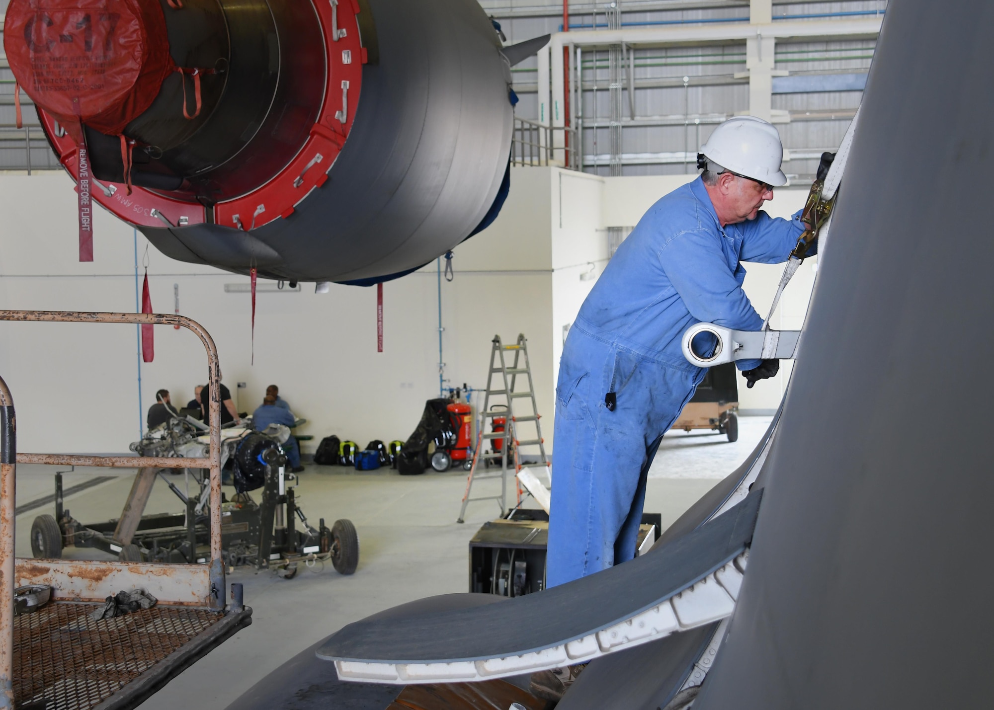 Bruce Natale, a contractor mechanic with Boeing, works on a U.S. Air Force C-17 Globemaster III at Al Udeid Air Base, Qatar, Feb. 25, 2017. The C-17 aircraft was lifted up inside a Qatari hangar in order to allow maintenance on it without interruption from the weather. (U.S. Air Force photo by Senior Airman Miles Wilson)