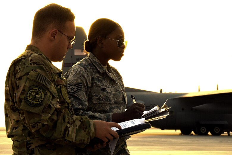 U.S. Air Force Staff Sgt. Claire Niba, an aerospace medical technician with the 379th Expeditionary Medical Group, right, coordinates luggage transfer with Staff Sgt. Ryan Edwards, an aeromedical evacuations technician with the 379th Expeditionary Aeromedical Evacuation Squadron at Al Udeid Air Base, Qatar, March 8, 2017. These technicians are a key component of patient transfer between arrival and departure of personnel from around the U.S. Central Command area of responsibility.  (U.S. Air Force photo by Senior Airman Cynthia A. Innocenti)