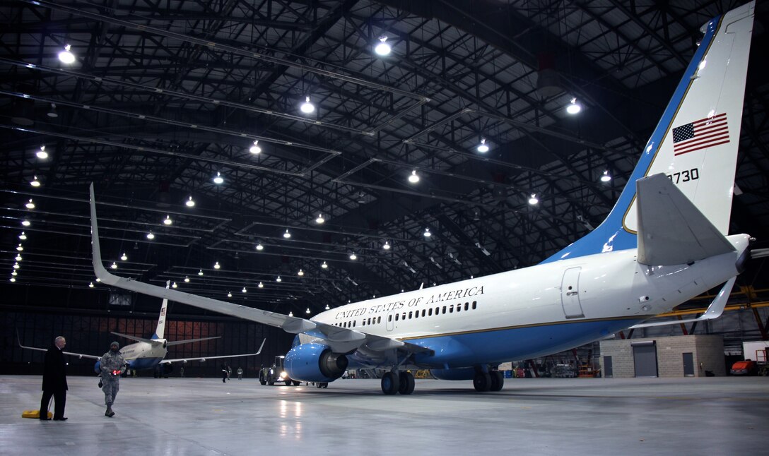 932nd Airlift Wing maintenance and operations personnel had a very early 0300 showtime to launch a cold mission on March 11, 2017, Scott Air Force Base, near Belleville, Illinois. At left, the commander of the 932nd AW, Col. Jonathan Philebaum, helps his 932nd Maintenance Group to pull the C-40C aircraft chalks, as the maintenance "wing walker" with red lights in hand, watches the clearance edges on the hangar doors.  Wing walkers are designated on both sides of the plane to walk along with the plane as it backs up out of the hangar, ensuring room to get the plane out safely.  (U.S. Air Force photo by Lt. Col. Stan Paregien)
