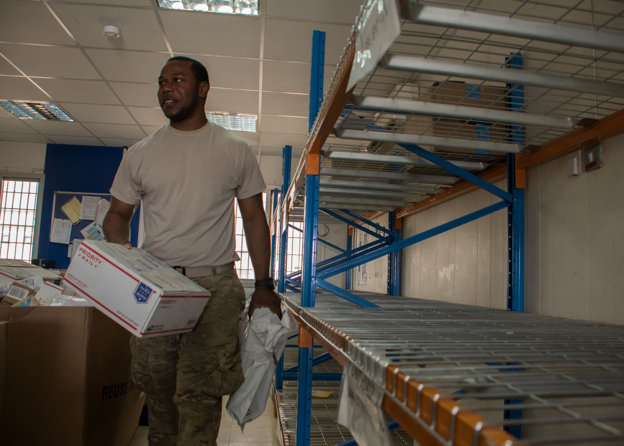 Spc. Michael Gray, an Army food service specialist, helps put mail in correct location at the post office here March 11, 2017. Gray, and other volunteers, sorted through two truckloads of mail that day. (U.S. Air Force photo /Senior Airman Andrew Park)
