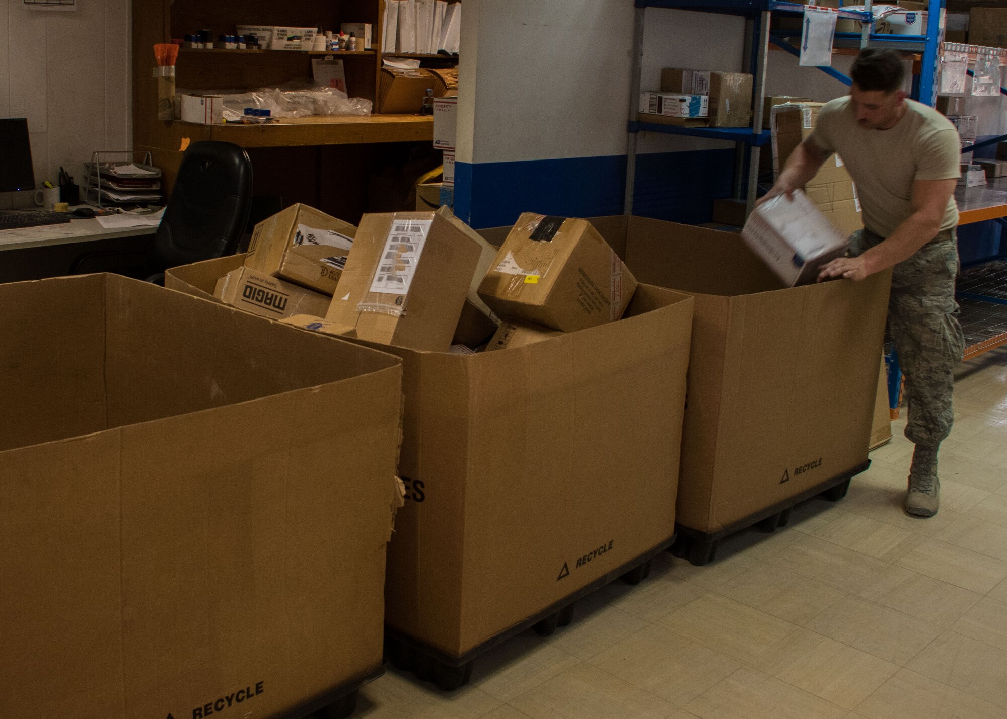 Airman Brent Downs, a 386th Expeditionary Logistics Readiness Squadron supply journeyman, unloads mail from a tri-wall at the post office here March 11, 2017. Downs was one of several volunteers who helped the post office contractors sort through incoming mail. (U.S. Air Force photo illustration/Senior Airman Andrew Park)