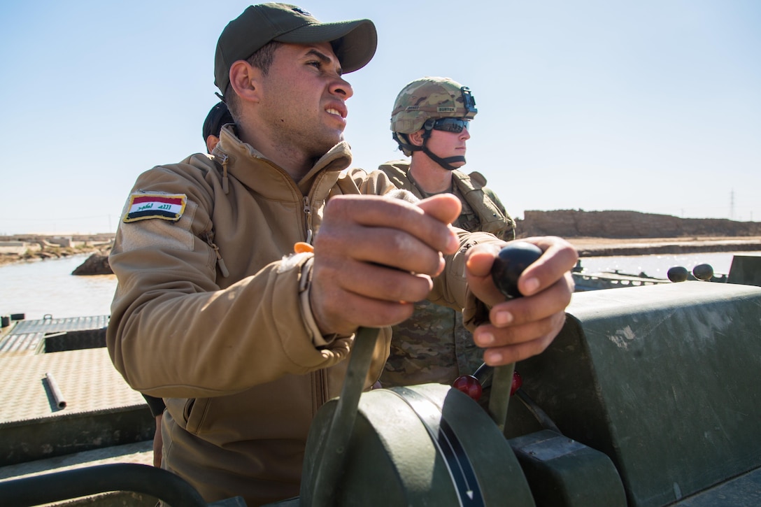 An Iraqi engineer operates a boat during assault bridging training at Camp Taji, Iraq, last month. U.S. soldiers trained Iraqi soldiers to quickly place standard ribbon bridges in support of Combined Joint Task Force Operation Inherent Resolve. Army photo by Spc. Christopher Brecht