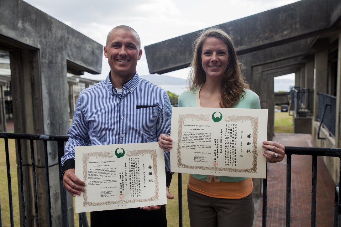 Sgt. Matthew Kreitzer and Dawn Kreitzer receive a certificate of appreciation from the Nago City Board of Education, at the Uruma City Ishikawa District Community Center, in Nago City, Okinawa, Japan, March 7, 2017. The certificate was presented as a thank you for their volunteer efforts during the Nago English Camp. Volunteers at the camp spent the majority of their time teaching Okinawan children how to read and write in English. Sgt. Kreitzer is an imagery analyst with 3rd Intelligence Battalion, III Marine Expeditionary Force Headquarters Group. The couple hails from Dayton, Ohio. (U.S. Marine Corps Photo by Lance Cpl. Jonah Baase)