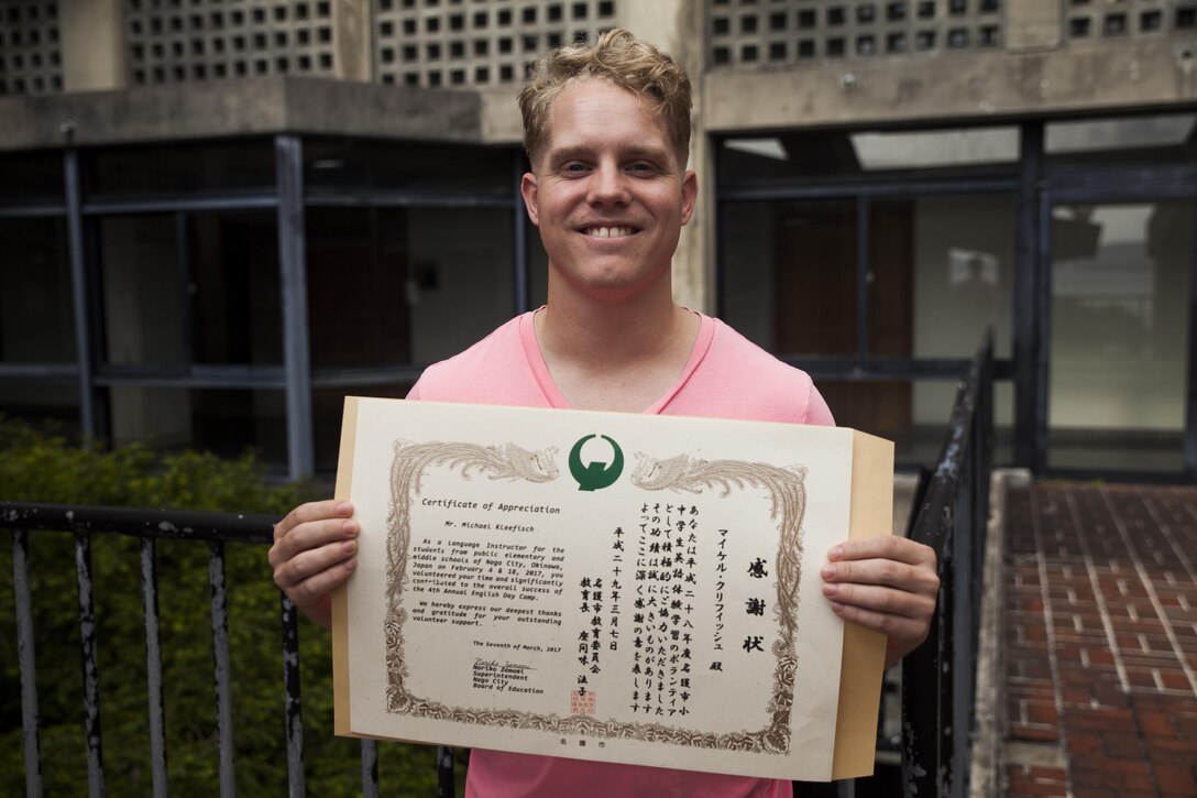 Lance Cpl. Michael Kleefisch receives a certificate of appreciation from the Nago City Board of Education, at the Uruma City Ishikawa District Community Center, in Nago City, Okinawa, Japan, March 7, 2017. The department recognized Kleefisch’s volunteer efforts at the Nago English Camp. Volunteers at the camp spent the majority of their time teaching Okinawan children how to read and write in English. Kleefisch from Athens, Alabama, is a meteorologist with 3rd Intelligence Battalion, III Marine Expeditionary Force Headquarters Group.  (U.S. Marine Corps Photo by Lance Cpl. Jonah Baase)
