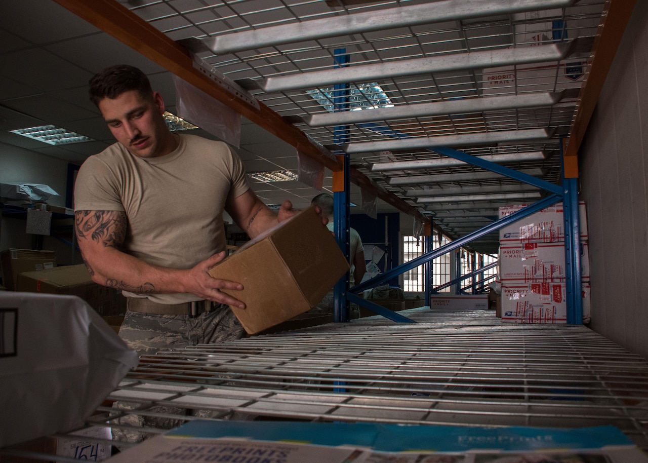 Airman Brent Downs, a 386th Expeditionary Logistics Readiness Squadron supply journeyman, places a box in its designated location at the post office here March 11, 2017. Post office contractors and volunteers sort and stow mail not only for the 386th but other branches and coalition partners around base as well.  (U.S. Air Force photo illustration/Senior Airman Andrew Park)
