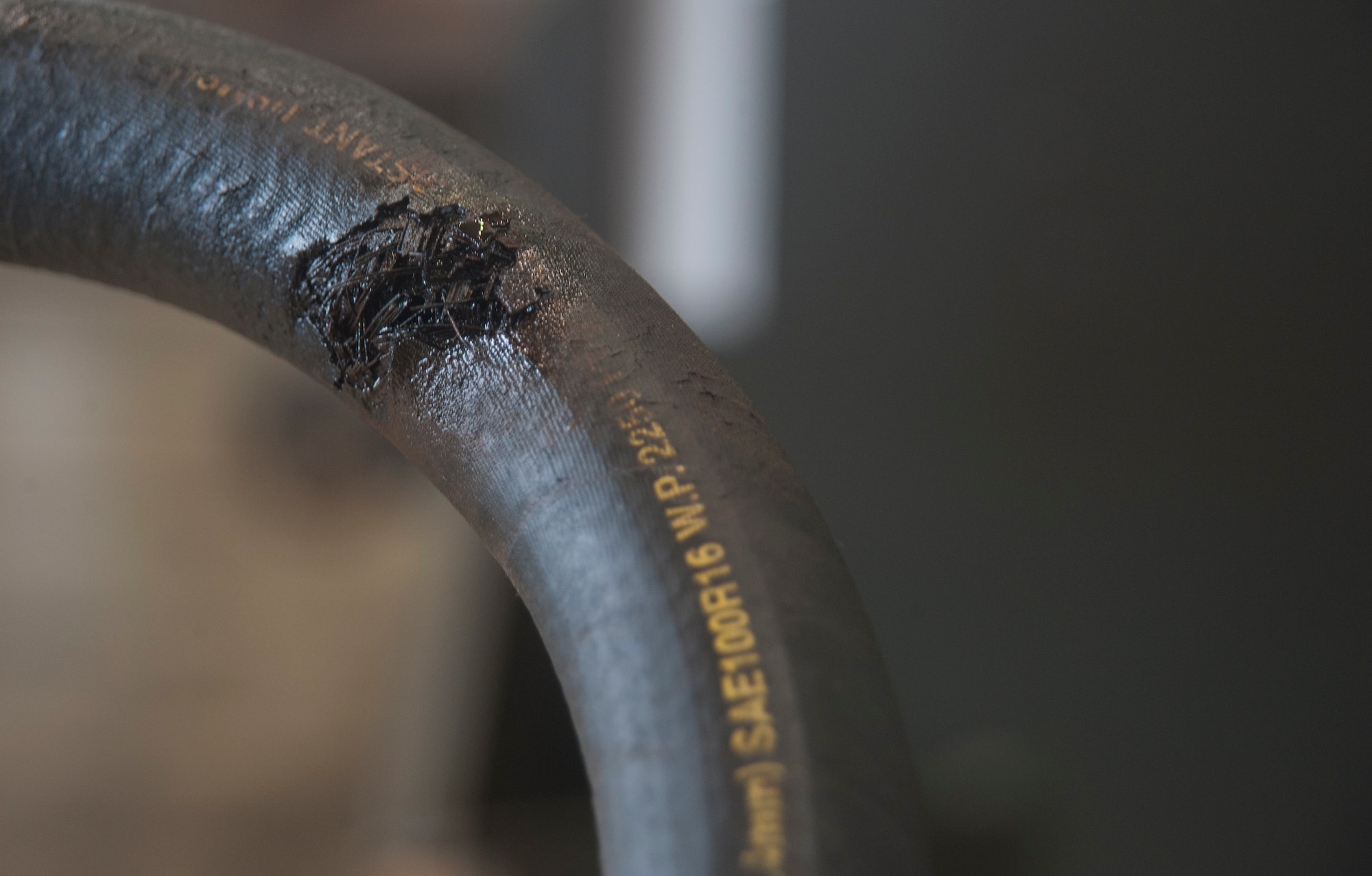 A damaged hydraulic hose was removed from a dump truck March 13, 2017, at Kadena Air Base, Japan. Scuffs, scratches and continues rubbing, paired with incredibly high pressure per square inch, can lead to dangerous hydraulic line failure. The 18th Logistics Readiness Squadron takes care to ensure that these machines are not out of service long, keeping the Kadena mission moving forward. (U.S. Air Force photo by Airman 1st Class Quay Drawdy)